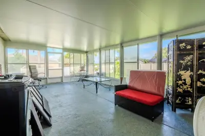 a living room with a red chair and a table at Flint and Kingscrest, LLC - Private Rooms in Shared Home in Orlando