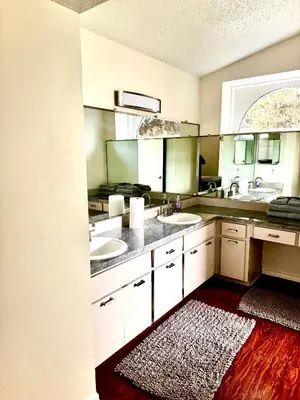 a bathroom with two sinks and two mirrors at Tropical Paradise in Orlando