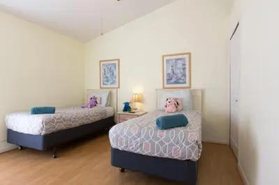 two beds in a small room with white walls at Indian Creek Vacation Home Close to Disney in Orlando
