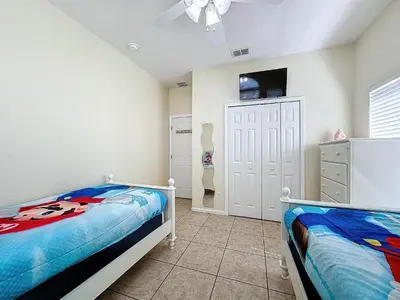 a bedroom with two beds and a flat screen tv at Walk to Silver Spurs Rodeo and Heritage Park in Kissimmee