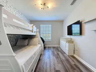 a bedroom with a bunk bed and a tv at Beautiful Three bed condo, Minutes from Disney in Kissimmee