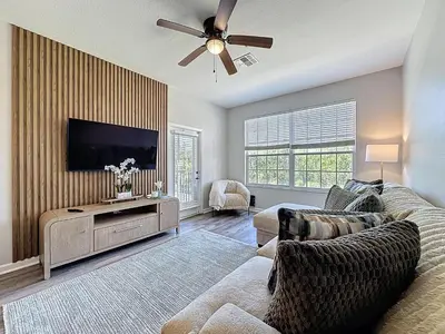 a living room with a couch and a flat screen tv at Beautiful Three bed condo, Minutes from Disney in Kissimmee