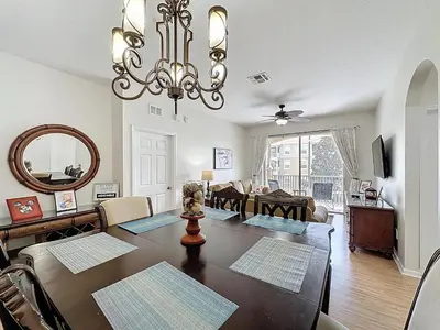 a dining room and living room with a dining table at Magical 3BR/2BA Disney-Themed Condo in Orlando
