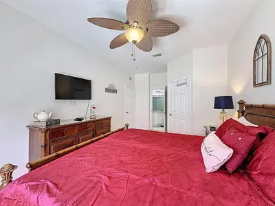 a bedroom with a red bed and a ceiling fan at Magical 3BR/2BA Disney-Themed Condo in Orlando