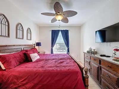a bedroom with a red bed and a ceiling fan at Magical 3BR/2BA Disney-Themed Condo in Orlando