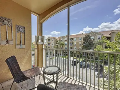 a balcony with two chairs and a table and a window at Magical 3BR/2BA Disney-Themed Condo in Orlando