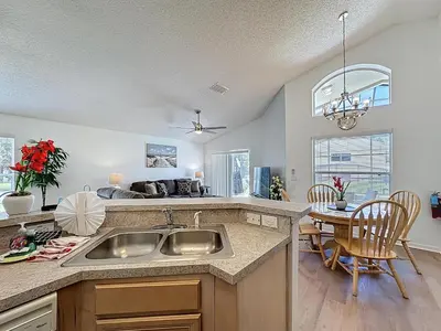 a kitchen with a sink and a dining room at Emerald Island 4Bd/3Ba Villa, 3 miles to Disney in Kissimmee