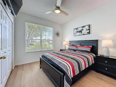 a bedroom with a bed and a window at Emerald Island 4Bd/3Ba Villa, 3 miles to Disney in Kissimmee