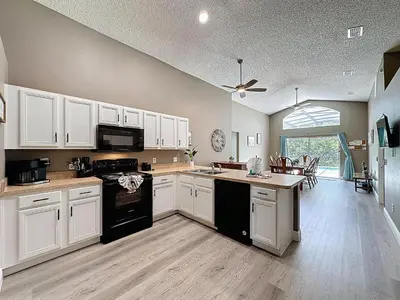 a large kitchen with white cabinets and a kitchen island at Terra Verde Resort 4 Bed Pool/Spa Villa in Kissimmee