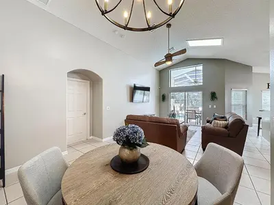 a living room with a table and chairs at Casa del Sol at Indian Creek Four Corners in Kissimmee