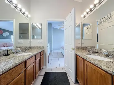 a bathroom with two sinks and two mirrors at Casa del Sol at Indian Creek Four Corners in Kissimmee