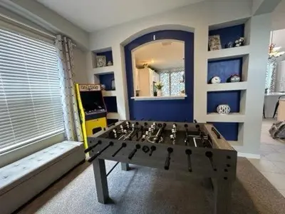 a living room with a table in the middle of a room at Emerald Island Resort 6 Bed Pool & Spa in Kissimmee