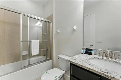 a bathroom with a toilet and a sink and a shower at 7416 Encore Reunion poolspa 11 guests 5 bdrs BBQ in Orlando