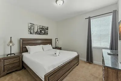 a bedroom with a large bed and a window at 7416 Encore Reunion poolspa 11 guests 5 bdrs BBQ in Orlando