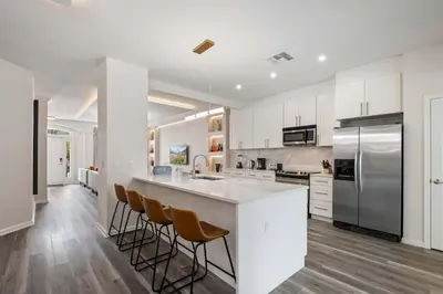 a kitchen with white cabinets and stainless steel appliances at 2540HS 6Bedrooms Disney Villa Sleeps 20 with Pool & Spa in Orlando