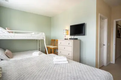 a bedroom with a bunk bed and a tv at Vista Cay Townhome Near Universal & Disney in Orlando
