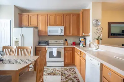 a kitchen with wooden cabinets and a white stove top oven at Vista Cay Townhome Near Universal & Disney in Orlando