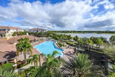 an aerial view of a resort swimming pool with a lake at Vista Cay Townhome Near Universal & Disney in Orlando