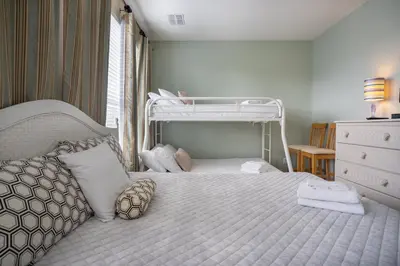 a bedroom with a white bed with a bunk bed at Vista Cay Townhome Near Universal & Disney in Orlando