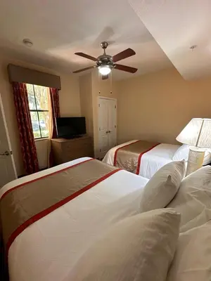 a bedroom with two beds and a ceiling fan at Central Location to all Parks and Convention center in Orlando