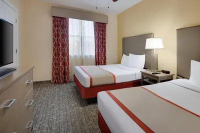 a hotel room with two beds and a flat screen tv at Central Location to all Parks and Convention center in Orlando