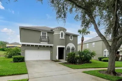 a house with a garage and a tree at Ever After Estate in Kissimmee