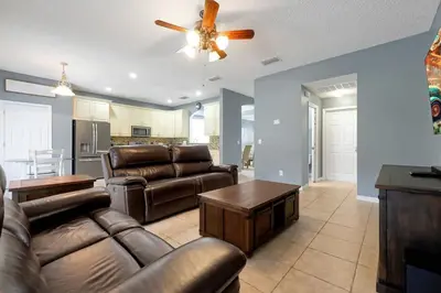 a living room with leather furniture and a ceiling fan at Ever After Estate in Kissimmee