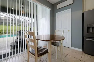 a dining room with a wooden table and chairs at Ever After Estate in Kissimmee