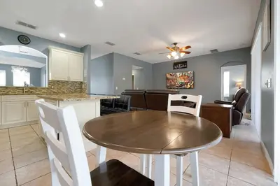 a dining room and kitchen with a table and chairs at Ever After Estate in Kissimmee