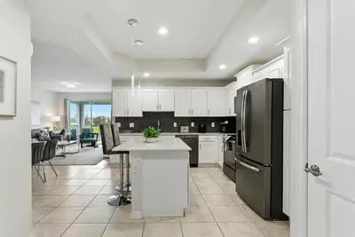a kitchen with white cabinets and a black refrigerator at Storey Lake condos by Une Homes in Kissimmee