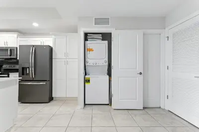 a kitchen with white cabinets and a refrigerator at Storey Lake condos by Une Homes in Kissimmee