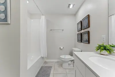 a white bathroom with a toilet and a sink at Storey Lake condos by Une Homes in Kissimmee