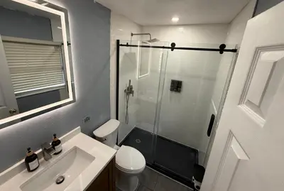 a bathroom with a shower and a toilet and a sink at Signature Suite in Orlando