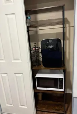 a microwave sitting on a shelf next to a door at Signature Suite in Orlando