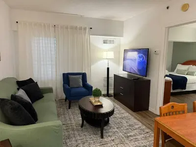 a living room with a couch and a bed at SkySuite 5min to Universal Park in Orlando