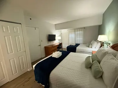 a hotel room with two beds and a television at SkySuite 5min to Universal Park in Orlando
