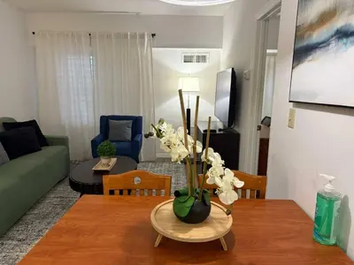 a living room with a table with flowers on it at SkySuite 5min to Universal Park in Orlando