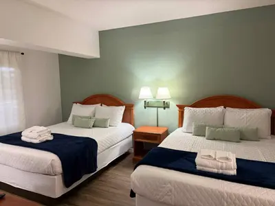 a hotel room with two beds with towels on them at SkySuite 5min to Universal Park in Orlando