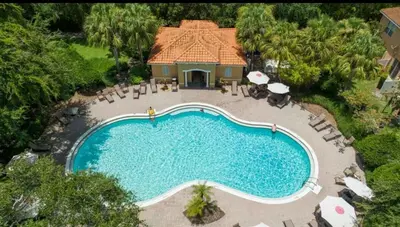 an overhead view of a swimming pool with chairs and umbrellas at 2BR Villa Near Disney, Gated community with Pool in Kissimmee