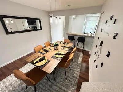 a dining room with a table and chairs and a refrigerator at 2BR Villa Near Disney, Gated community with Pool in Kissimmee