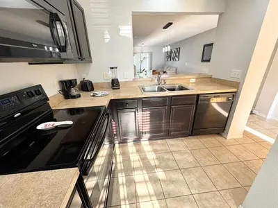 a kitchen with a sink and a stove top oven at 2BR Villa Near Disney, Gated community with Pool in Kissimmee