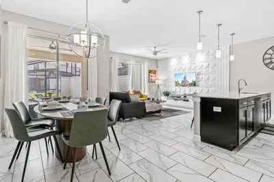 a kitchen and living room with a table and chairs at Casa Familiar no Storey Lake c/ Piscina in Kissimmee