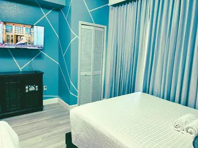 a blue bedroom with a bed and a tv at Resort Lake Buena Vista - 2 Quartos in Orlando
