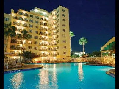 a hotel with a swimming pool in front of a building at Apartamento Aconchegante no Enclave Suites in Orlando