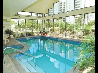 a large swimming pool in a building with windows at Apartamento Aconchegante no Enclave Suites in Orlando