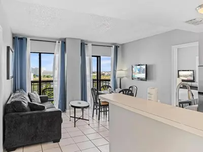 a living room with a couch and a table with chairs at Apartamento Aconchegante no Enclave Suites in Orlando