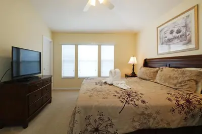 a bedroom with a bed with a towel animal on it at The Orlando Hideaway Family Townhome Steps from Disney 3BR 3BA in Kissimmee