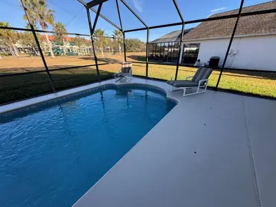 a swimming pool with two chairs and a house at Casablanca Villa home in Kissimmee