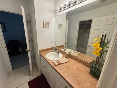 a bathroom with a sink and a large mirror at Cumbrian Sunset Villa home in Kissimmee