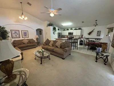 a living room with two couches and a kitchen at Cumbrian Sunset Villa home in Kissimmee